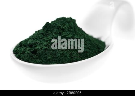 Integratori vitaminici e minerali per i vegetariani in polvere di spirulina in un cucchiaio di ceramica, primo piano Foto Stock