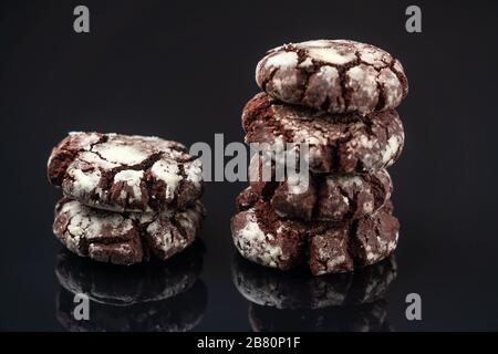 Biscotti al cioccolato a base di rinkle, primo piano su sfondo nero con un riflesso Foto Stock