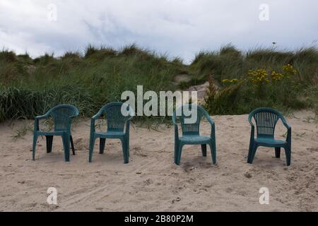 Quattro sedie verdi sul prato in spiaggia