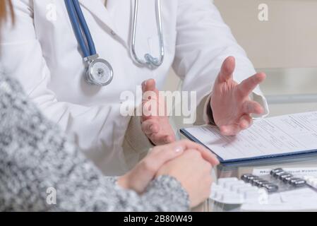 Medico di parlare con il suo paziente nell'ufficio del medico Foto Stock