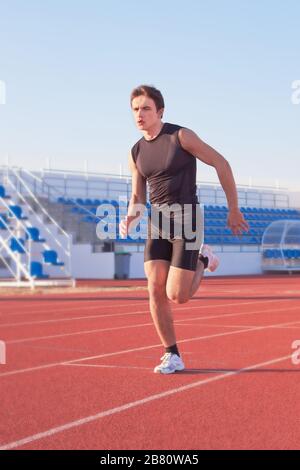 Un giovane inizia a correre nello stadio. Tapis roulant. Foto Stock