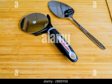 Pizza Wheel e spatola su Bambù tagliere Foto Stock