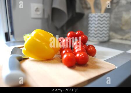 Pomodori ciliegini e peperoni sul tagliere. Foto Stock