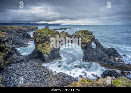 Impressionante arco di roccia di basalto eroso dal surf dell'oceano atlantico, la penisola di Snaefellsness, Islanda occidentale Foto Stock
