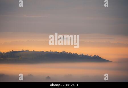 Il sole sorge sui livelli del Somerset con Glastonbury Tor sullo sfondo. Foto Stock