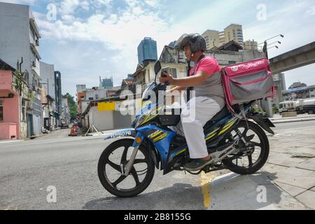 Kuala Lumpur, Malesia. 19 Mar 2020. Un deliveryman consegna il cibo a Kuala Lumpur, Malesia, 19 marzo 2020. La Malesia ha annunciato giovedì 110 nuovi casi confermati di COVID-19, portando il numero totale di casi a 900, ha detto il Ministero della Sanità. Credit: Chong Voon Chung/Xinhua/Alamy Live News Foto Stock