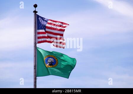 Contro il cielo. Bandiera degli Stati Uniti d'America e bandiera verde di Washington - bandiera di stato. Foto Stock