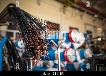 Fascio di fili è sospeso da tubi nella produzione di componenti elettronici per grandi strutture di fabbrica. Progettazione di parti industriali Foto Stock