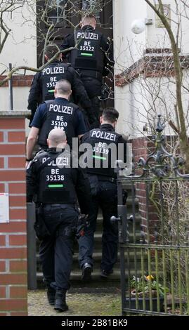 Berlino, Germania. 19 Mar 2020. Gli agenti di polizia entrano in una casa durante un raid di appartamento. Dopo il divieto del gruppo dei cittadini del Reich "popoli e tribù della Germania unita", le incursioni si sono svolte in diversi stati federali. Credit: Carsten Koall/dpa/Alamy Live News Foto Stock