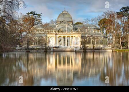 Il Palazzo di vetro, il Palazzo di Cristallo nel Parco del Retiro, Madrid, Spagna. Storico padiglione di vetro ed ex serra. Vista panoramica a lunga esposizione con laghetto. Foto Stock