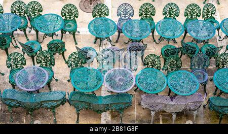 Sedie e tavoli vuoti in inverno, a la Valletta, Malta. Foto scattata dai giardini Upper Barrakka. Foto Stock