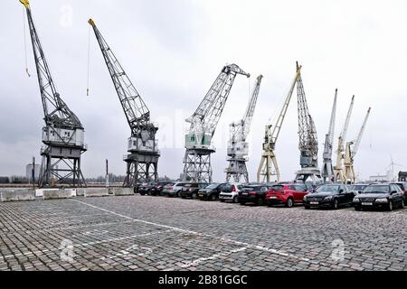 Vecchie autogru portuali nel parcheggio Rijnkaai sulla Schelda di Anversa. Foto Stock