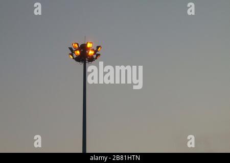 Polo arancione chiaro grande sulla strada, superstrada colonna di illuminazione di notte. Foto Stock