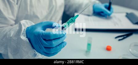 Mano di scienziato che tiene una siringa con vaccino del virus Foto Stock