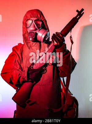 Uomo in costume da guerra chimico e maschera che tiene fucile Foto Stock