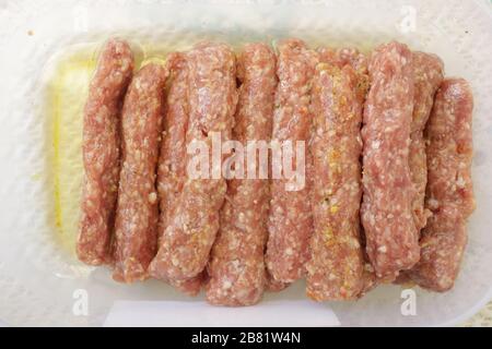 Carne macinata in forma di kebab pronti per il barbecue. Foto Stock