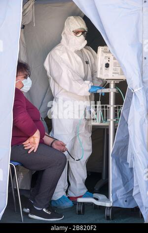 Campobasso,Regione Molise,Italia:un medico in tuta protettiva controlla l'ossigeno nel sangue ad un paziente nella tenda a triage situata di fronte al CA Foto Stock