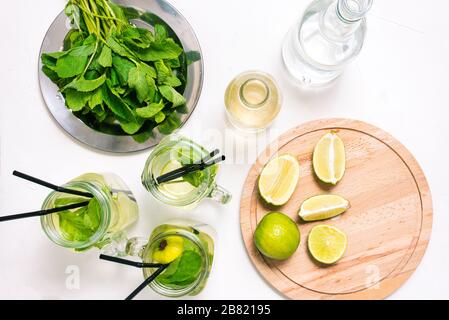 Preparare un cocktail mojito estivo. Ingredienti per una bevanda alcolica al tavolo. Foto Stock