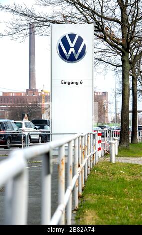19 marzo 2020, bassa Sassonia, Wolfsburg: Il logo Volkswagen AG si trova all'ingresso di un parcheggio per dipendenti di fronte allo stabilimento. Il crescente rischio di infezione e le drastiche conseguenze economiche della crisi corona costringeranno Volkswagen a chiudere i suoi impianti in Germania da giovedì sera (19 marzo 2020). Foto: Hauke-Christian Dittrich/dpa