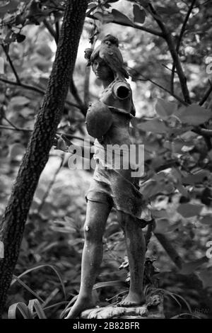 Foto in bianco e nero della statua di una donna in un giardino Foto Stock