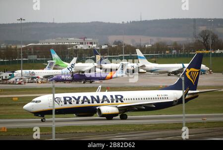 Un volo Ryanair partì con alcuni aerei Flybe atterrati appena entrati nell'amministrazione dell'aeroporto di Birmingham, poiché molte aziende si chiudono a causa del coronavirus. Foto Stock