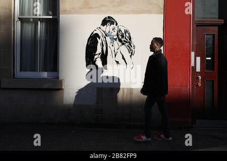 Un pezzo d'arte dell'artista, conosciuto come l'orso ribelle, è apparso su un muro di Bank Street a Glasgow. La nuova aggiunta all'arte di strada di Glasgow sta catturando la crisi globale di Coronavirus. Il pezzo presenta una donna e un uomo che si tira indietro per darsi un bacio. Foto Stock