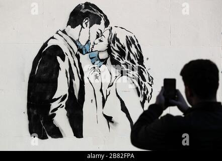 Un pezzo d'arte dell'artista, conosciuto come l'orso ribelle, è apparso su un muro di Bank Street a Glasgow. La nuova aggiunta all'arte di strada di Glasgow sta catturando la crisi globale di Coronavirus. Il pezzo presenta una donna e un uomo che si tira indietro per darsi un bacio. Foto Stock