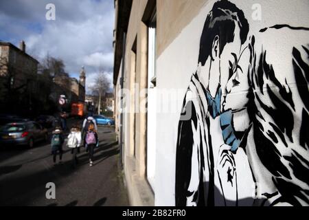 Un pezzo d'arte dell'artista, conosciuto come l'orso ribelle, è apparso su un muro di Bank Street a Glasgow. La nuova aggiunta all'arte di strada di Glasgow sta catturando la crisi globale di Coronavirus. Il pezzo presenta una donna e un uomo che si tira indietro per darsi un bacio. Foto Stock