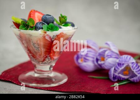 quinoa chia semi dessert con mandorle latte fragola lampone mirtillo kiwi fresco menta napkin Foto Stock