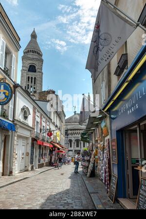 Strada con negozi a Montmartre che si affaccia sulla cupola della Basilica del Sacro cuore, Parigi, Ile-de-France, Francia Foto Stock