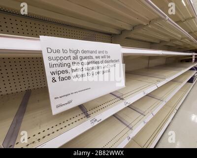 Durante un focolaio del coronavirus COVID-19, è visibile un cartello indicante che la vendita di determinati articoli sarà limitata, in quanto i clienti hanno acquistato tutta la carta igienica, i tovaglioli di carta, le forniture mediche, l'igienizzatore per le mani e altri articoli essenziali disponibili, lasciando scaffali vuoti in un negozio Target nella contea di Contra Costa; San Ramon, California, una regione in cui il virus è stato confermato essere attivamente diffusione, 12 marzo 2020. () Foto Stock