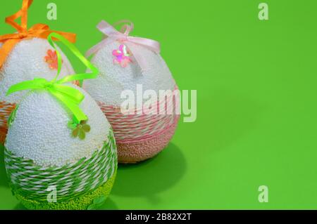 Uova di Pasqua su sfondo verde con spazio copia, decorazione fatta in casa per i saluti di festa Foto Stock