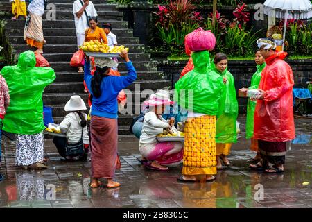 Donne locali che vendono mais alla pioggia alla cerimonia di Batara Turun Kabeh, al tempio di Besakih, Bali, Indonesia. Foto Stock