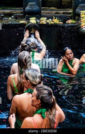 Visitatori stranieri bagnarsi al Tempio dell'acqua di Tirta Empugl, Bali, Indonesia. Foto Stock