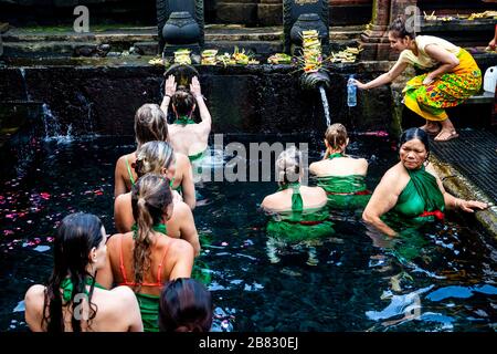 Visitatori stranieri bagnarsi al Tempio dell'acqua di Tirta Empugl, Bali, Indonesia. Foto Stock