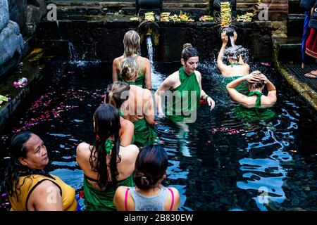 Visitatori stranieri bagnarsi al Tempio dell'acqua di Tirta Empugl, Bali, Indonesia. Foto Stock