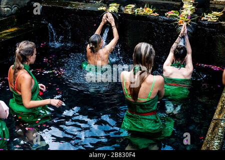 Visitatori stranieri bagnarsi al Tempio dell'acqua di Tirta Empugl, Bali, Indonesia. Foto Stock