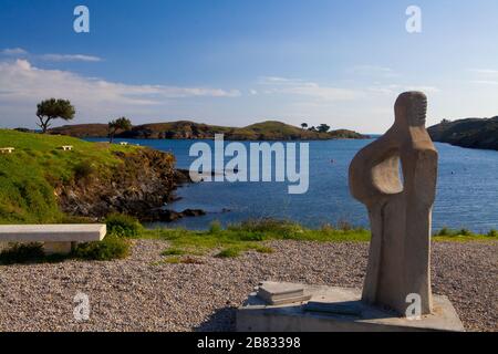 Una scultura di fronte al litorale del villaggio di Port Lligat in Costa Brava, Girona, Spagna. Foto Stock