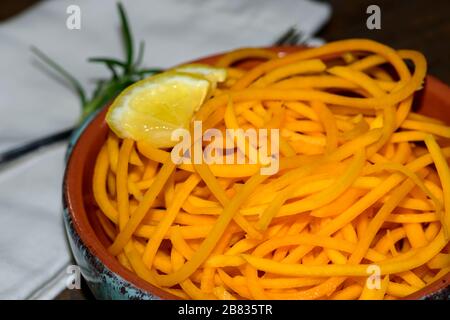 Ciotola di Butternut Squash Noodles fresco con fetta di limone e rametto di rosmarino. Foto Stock