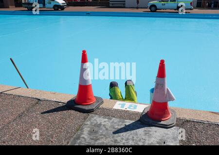 Gli operai dipingono una piscina blu sul lungomare di Llandudno, Conwy, Galles. Foto Stock