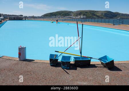Gli operai dipingono una piscina blu sul lungomare di Llandudno, Conwy, Galles. Foto Stock