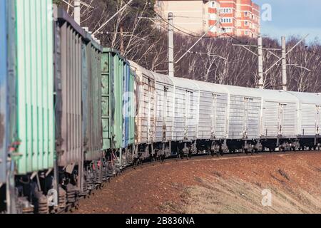 Carrozze thermos nel treno merci che si muove attraverso la foresta di primavera. Foto Stock