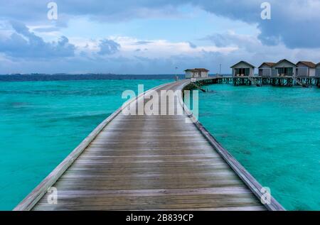 Atollo di Malé Nord, Maldive - Dicembre 29 2019 - un molo di legno verso le ville sull'acqua Foto Stock