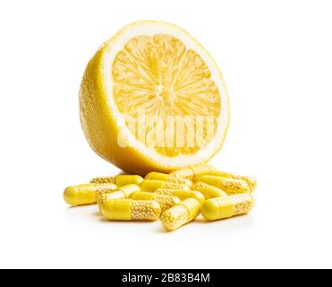 Capsule vitaminiche. Pillole di vitamina C e limone giallo isolato su sfondo bianco. Foto Stock
