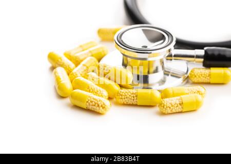 Capsule vitaminiche. Pillole di vitamina C e stetoscopio isolati su sfondo bianco. Foto Stock