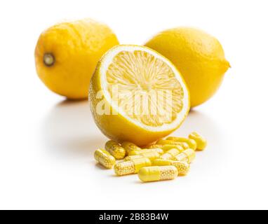 Capsule vitaminiche. Pillole di vitamina C e limone giallo isolato su sfondo bianco. Foto Stock