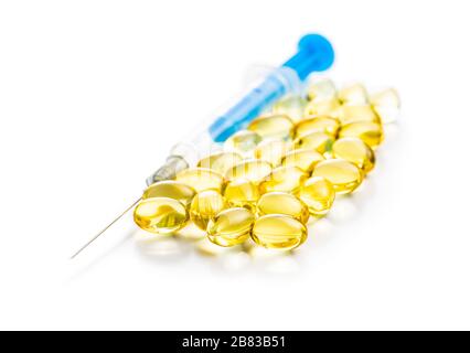 Omega 3 pillole. Capsule di supplemento di olio di pesce e siringa isolata su sfondo bianco. Foto Stock