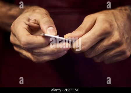 Un'immagine tagliata di barbiere in un elegante abbigliamento classico con un rasoio dritto. Foto Stock