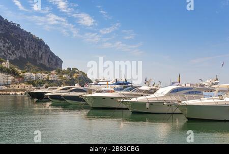 ISOLA DI CAPRI, ITALIA - AGOSTO 2019: Lussuosi yacht a motore allineati nel porto turistico dell'Isola di Capri. Foto Stock