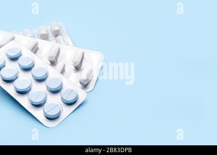 Pillole in confezioni blister su sfondo blu. Foto Stock